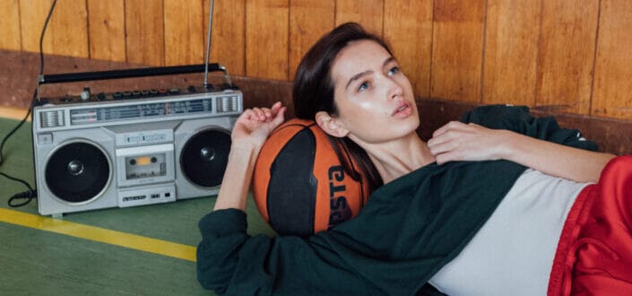 A woman lying on top of a ball listening to radio