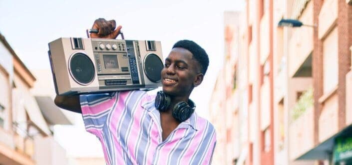 Man listening to music using boom box and headphones