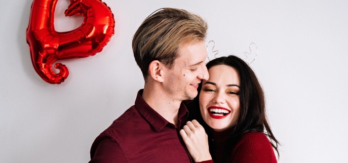 couple both wearing red and smiling