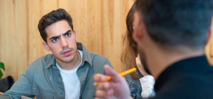 Guy staring at a speaker with a confused look