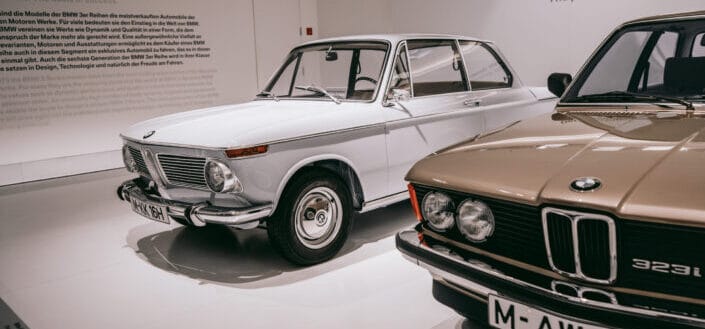 2 Vintage cars parked indoors