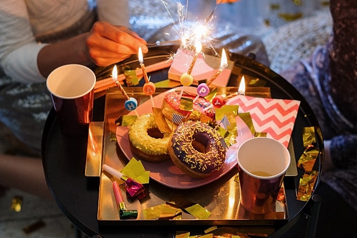 Donuts with candles and party sparkles.