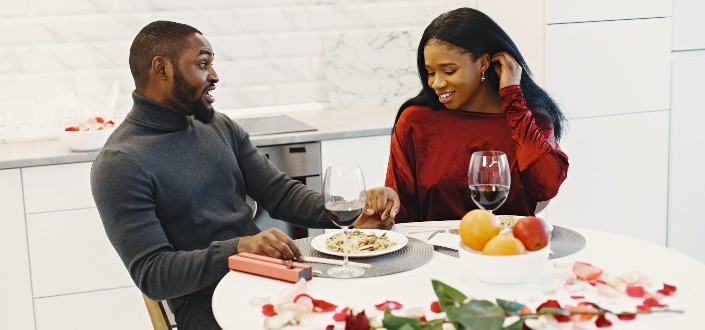 couple holding hands while having dinner