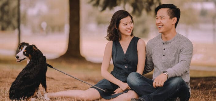 A couple talking happily with a dog