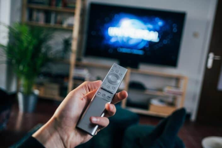 Person holding a remote while watching television