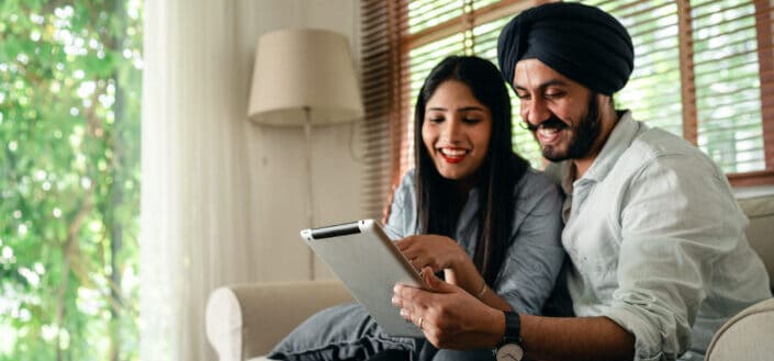 Couple smiling at a tablet