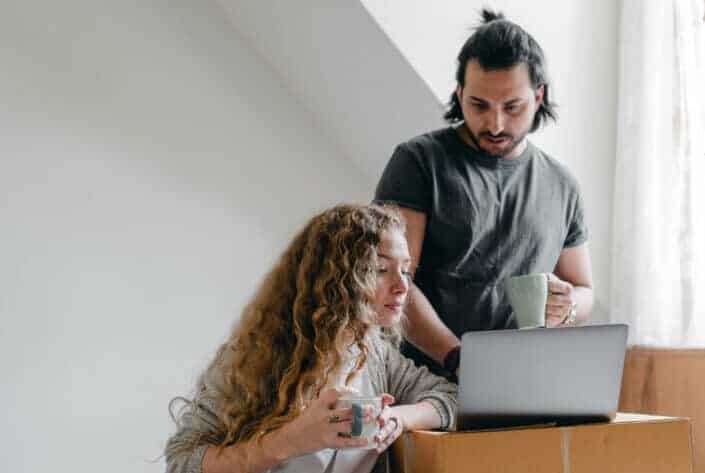 Couple drinking coffee and looking at a laptop