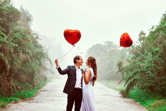 Valentines day questions to ask - couple looking at each other while holding balloons 