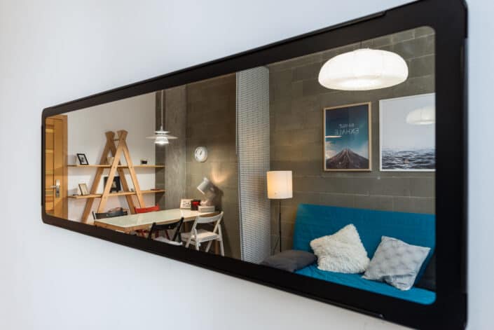 Long mirror reflecting a small condo unit