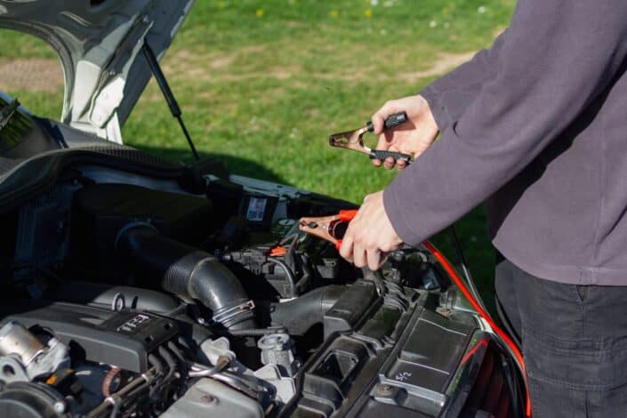 Guy jumpstarting a battery