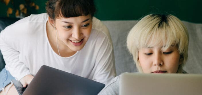 Two girls facing a laptop