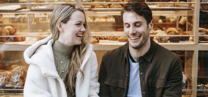 Cheerful young couple holding hands during date