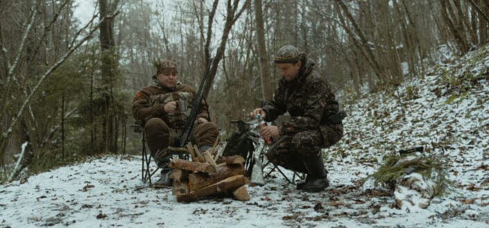 two man preparing bonfire in the woods