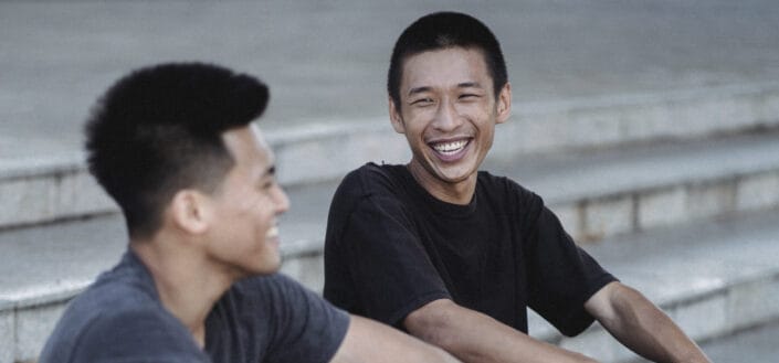 Happy friends sitting on a stairscase and chatting