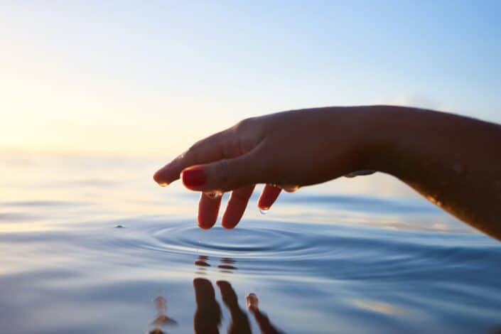 Hand touching water