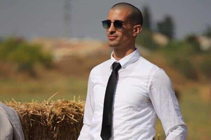 Man Standing Beside a Haystack