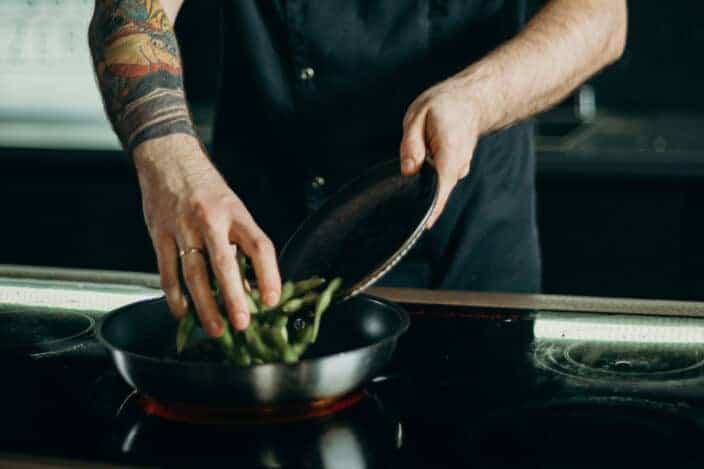 Tattooed guy cooking beans