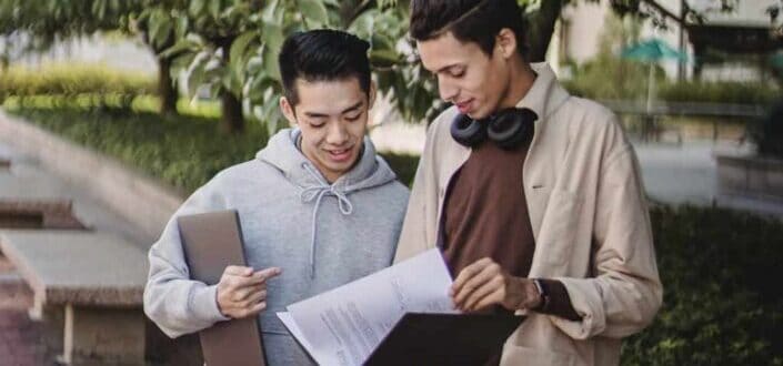 Two guys looking at a notebook