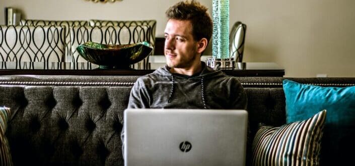 A man looking sideways while working on his laptop