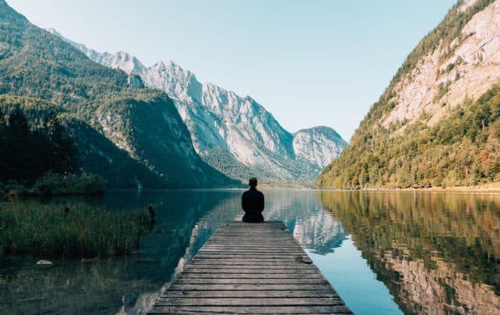 Person on a bridge near a lake