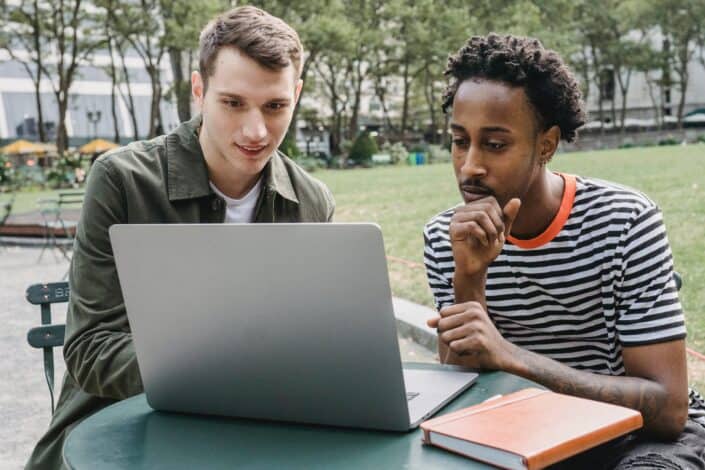 Two guys facing a laptop
