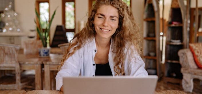 A woman smiling while using laptop