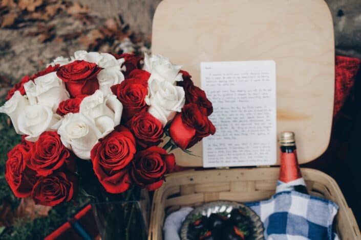 picnic basket with wine and bouquet of roses