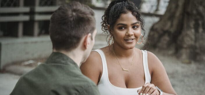 Positive ethnic woman having coffee break with anonymous boyfriend