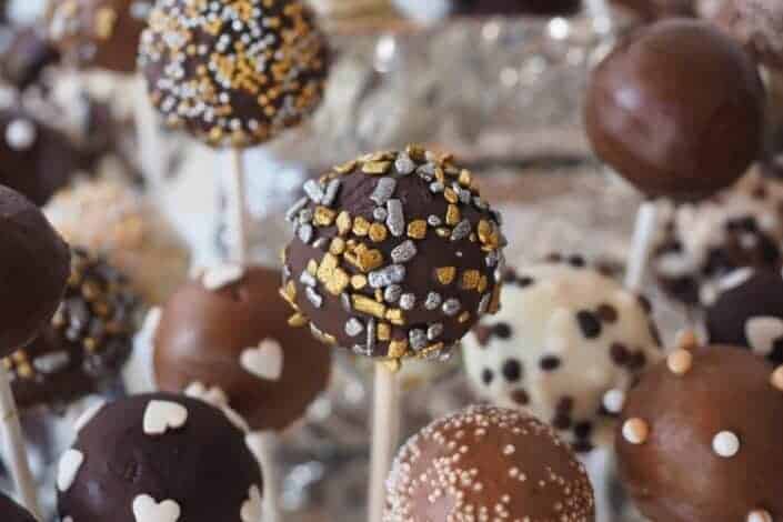 Round chocolate coated pastry on white stick