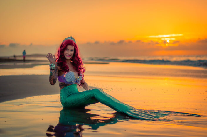 A woman dressed up as a mermaid by the beach