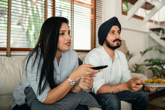 Couple Watching TV Together While Having Snacks