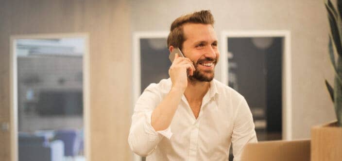 A guy happily talking on a phone.