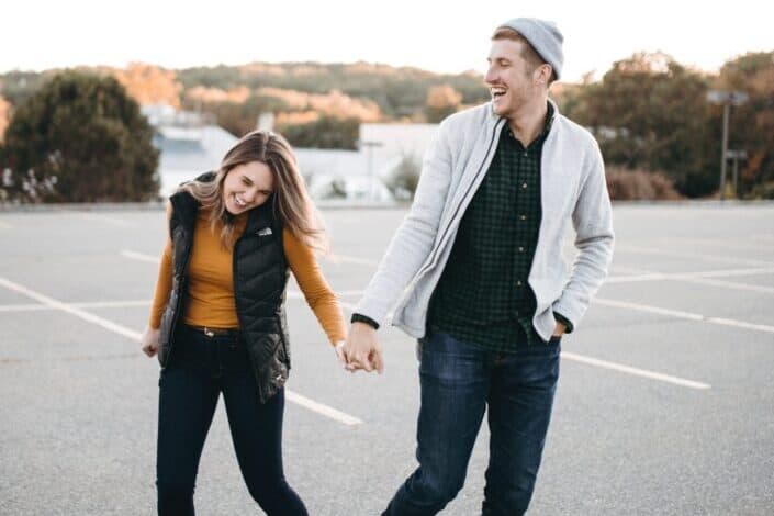 A couple laughing together in parking lot