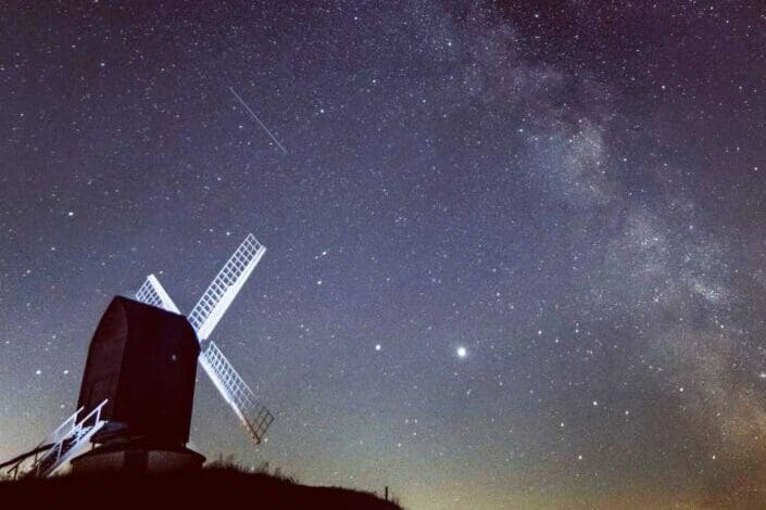 View of windmill with starry sky background.