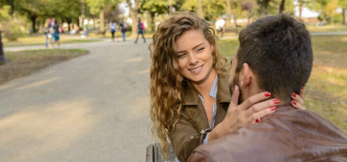 A woman holding a man's face