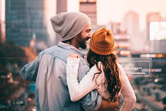 A couple hugging overlooking a city