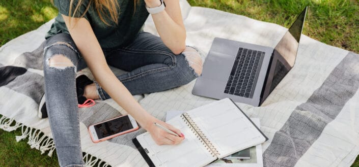 Woman with laptop sitting on blanket