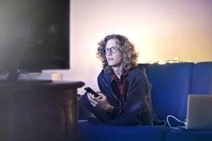 Nerdy Long-Haired Guy, Sitting and Watching TV.