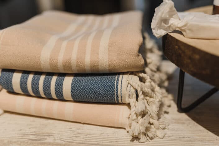 pile of blankets placed on wooden table