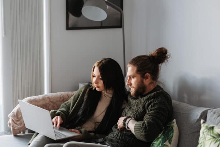 couple surfing the internet via laptop