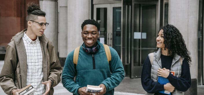 Students strolling near building while carrying books