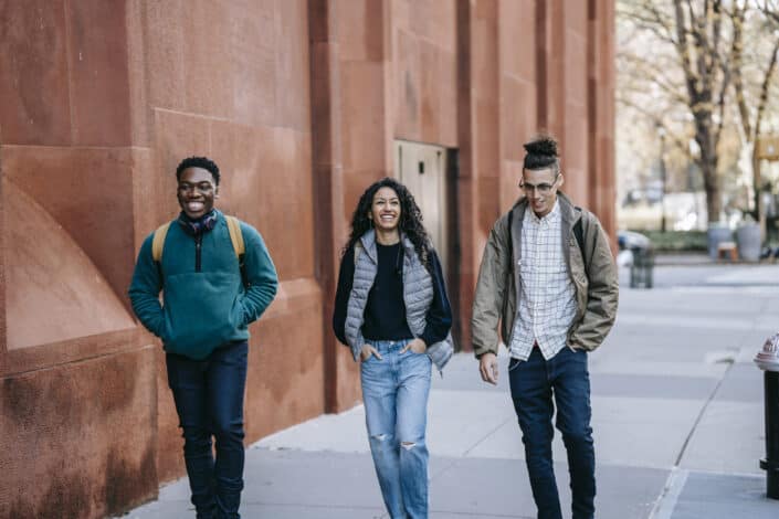 friends walking near an orange building