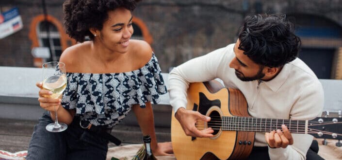 Man and woman holding acoustic guitars