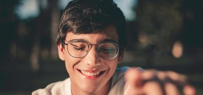 selective focus photography of smiling man wearing eyeglasses