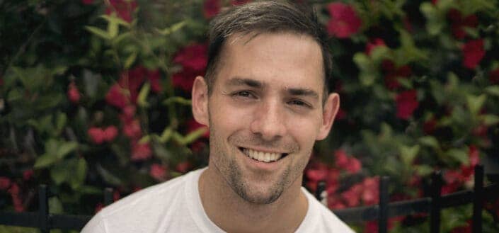 Photo of man wearing white shirt and smiling