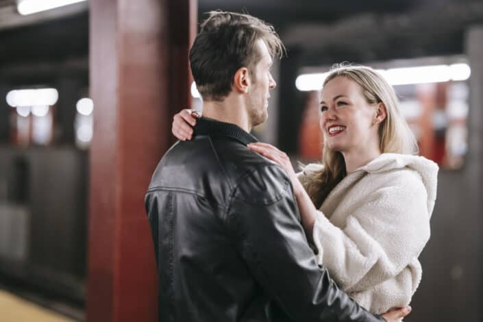 happy couple hugging in a train station