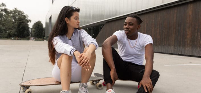 Diverse skaters resting on boards after training