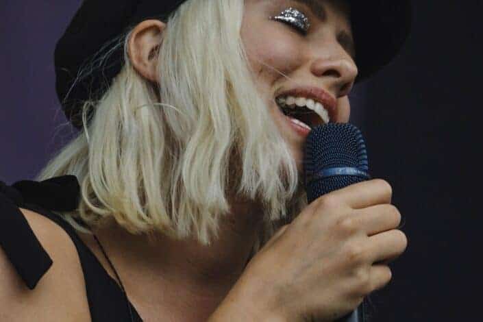 close up photography of a woman singing