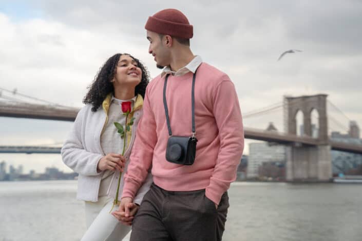 Happy hispanic couple having date on embankment