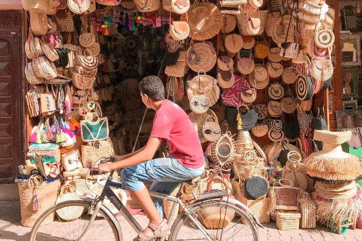 Man with a bike in front of a bag store